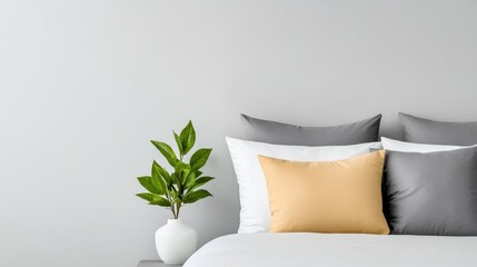 Modern minimalist bedroom with grey and white bedding and yellow accent pillow