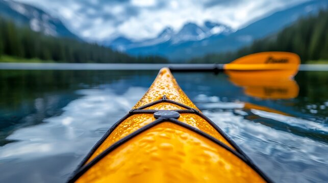 A yellow kayak on a lake with mountains in the background