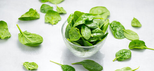 Obraz premium Spinach leaves in a transparent glass bowl isolated on white background. Heap of Baby spinach fresh leaves close up, Healthy vegan food, diet, dieting 