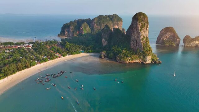 Railay Beach, Krabi, Thailand Beautiful beach and sea of Thailand at sunset Aerial view of Railay Beach, tourists and long-tail boats, lush rainforest and emerald sea	