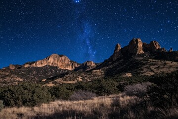 Stunning night landscape with milky way rising above the mountains and desert vegetation