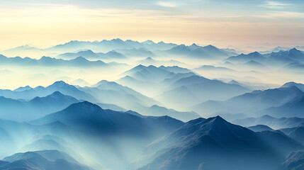 Misty mountain landscape at sunrise with layers of blue hues in the sky. 