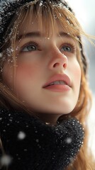 Young woman gazes upward with a serene expression while snow softly falls around her in a winter landscape