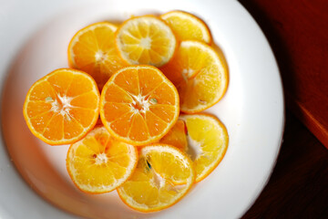 Perfectly Sliced Orange with white dish on table. Stock Photo
