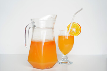 Refreshing Orange Juice in Glass Jug and Tumbler.  on white background. Premium Stock Image