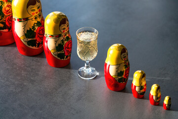 Shots of Georgian ChaCha, a traditional grape spirit, displayed with colorful Russian nesting dolls...