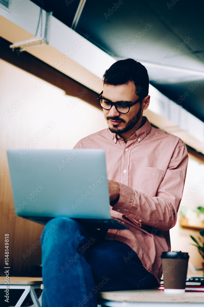 Poster young male it developers cooperating on programming via laptop computers doing productive job togeth