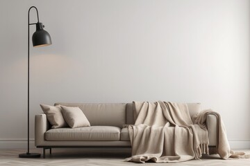 Industrial black lamp next to beige couch with blanket and pillows, copy space on empty white wall