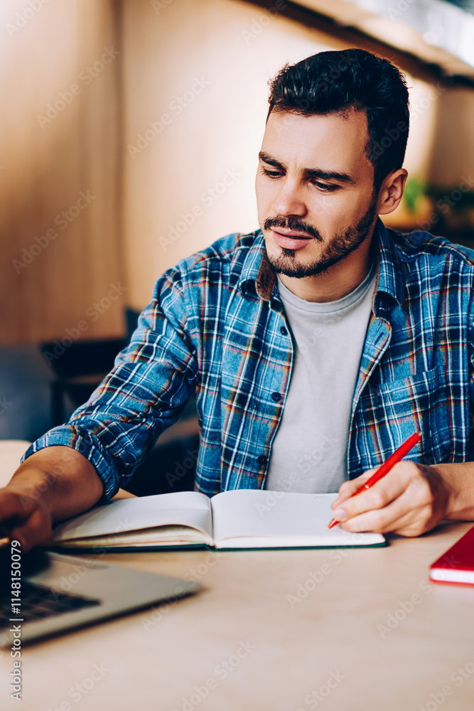Poster male student browse information for studying language via online courses on netbook in coworking off