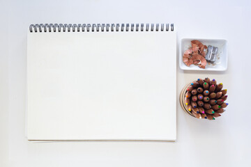 Minimalist Creative Workspace with Art Supplies, colored pencils and blank spiral sketchpad