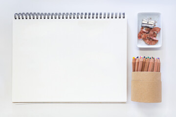 Minimalist Creative Workspace with Art Supplies, colored pencils and blank Sketchpad