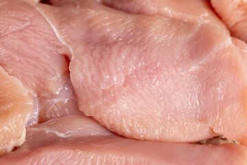 a lot of a piece of fresh chicken meat in close-up lies on paper