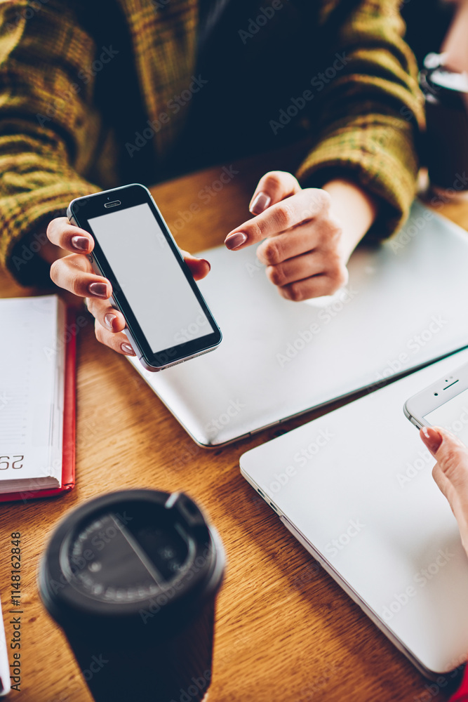 Poster cropped image of hipster girl showing application on smartphone with blank screen area to friend whi