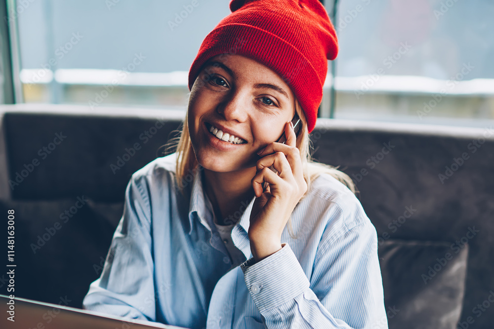 Poster portrait of successful female freelancer in stylish red hat talking calling to mobile operator and t