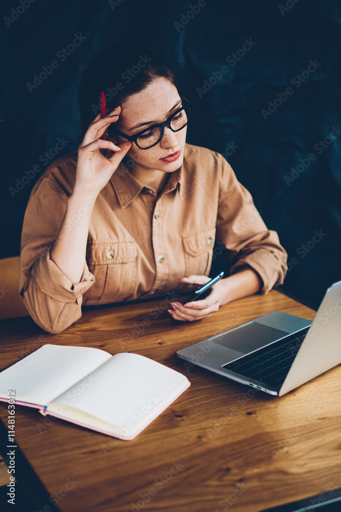 Poster pensive hipster student reading information on websites and preparing for exam at laptop device conn