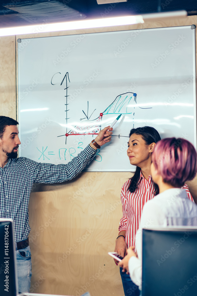Poster young man coach pointing on flip chart with diagram explaining studying materiel in stylish classroo