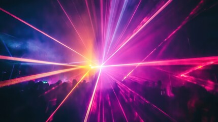 Crowd silhouettes at vibrant laser light show.