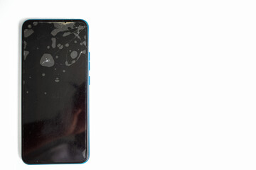 Phone with cracked screen resting on a white background