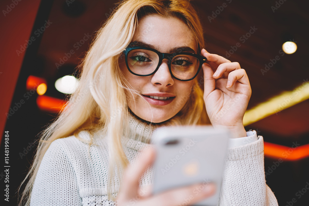 Poster selective focus on female blogger looking at camera holding smartphone for checking update in networ
