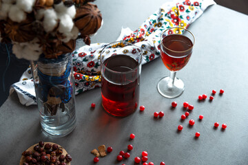 Glasses and a decanter with cranberry juice on a gray table surface.