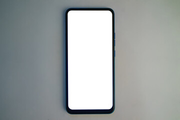 Modern smartphone resting on a plain surface with a blank screen