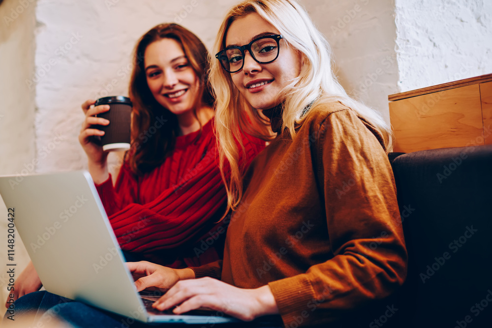 Poster portrait of hipster girl browsing on netbook resting on break with best friend, positive female teen