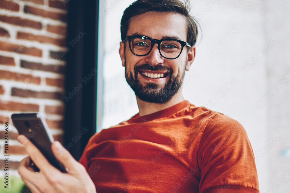 Aufkleber half length portrait of positive bearded young man in eyeglasses for vision correction smiling at ca