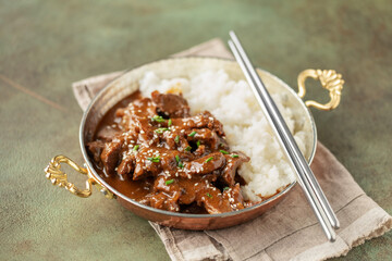 Homemade Korean Beef Bulgogi BBQ with Sesame Seeds and Scallion and rice in skillet