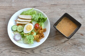 fresh vegetable topping boiled egg topping crispy fried taro dressing Indian sauce salad on plate 