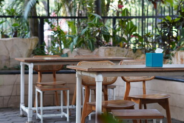 A minimalist wooden table and chairs in a cafe with a blue tissue holder in the middle without anyone sitting on it