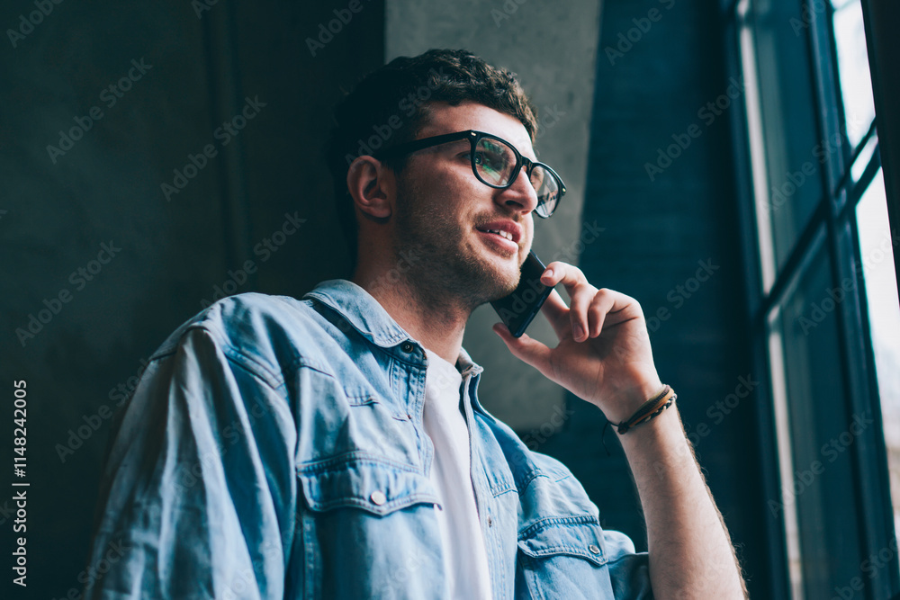 Poster positive male user in spectacles calling to friend via application on cellular phone connected to wi