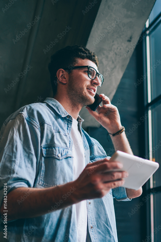 Poster successful hipster guy making positive conversation with friend while downloading file on digital ta