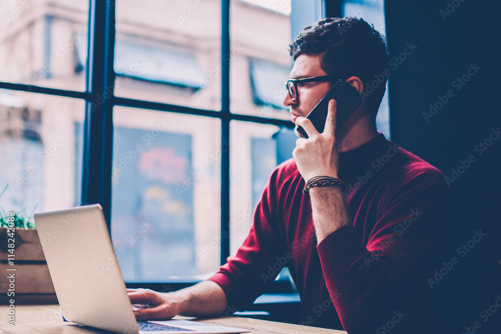 Poster serious male freelancer calling to operator for checking account balance while sitting at desktop wi