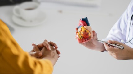 A doctor works at a desk in the hospital,discussing heart diseases such as coronary artery...