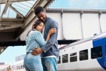 Couple shares a tender moment at the train station as they embrace before departure