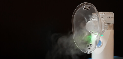 Portable nebulizer producing vapor in a dark setting for respiratory therapy use