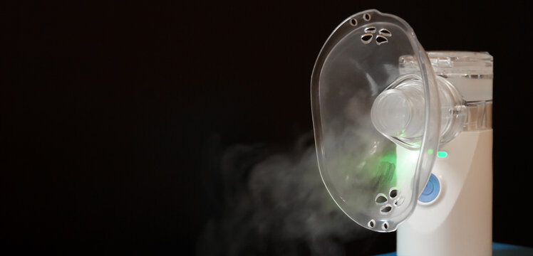 Portable nebulizer producing vapor in a dark setting for respiratory therapy use