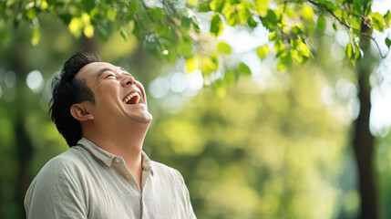 Joyful man laughing heartily in natural outdoor setting