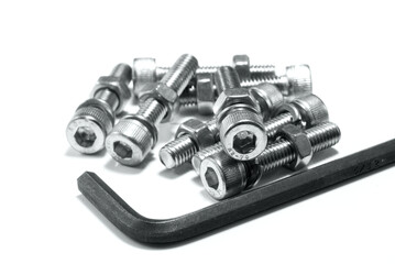 Set of silver allen bolts with nuts and Grover washers, and an allen wrench, isolated on a white...