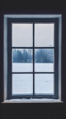 Naklejka premium A snowy landscape viewed through a window, creating a serene winter atmosphere.
