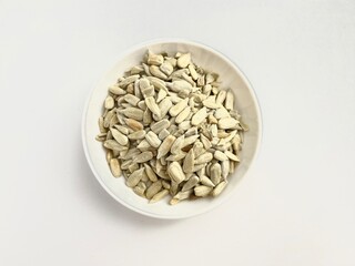 Bowl of roasted sunflower seeds in white background