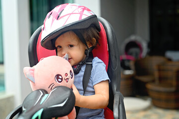 Toddler girl in helmet on bicycle