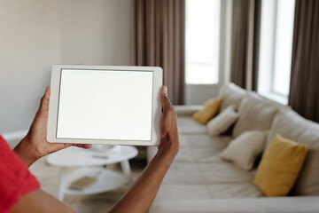 Medium close up of unrecognizable female hands holding white rectangular tablet with total white...