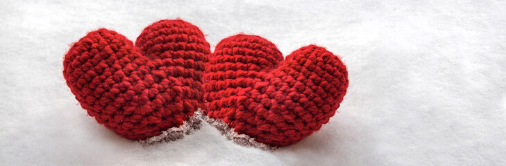 Beautiful two red wool hearts handmade laid in the snow