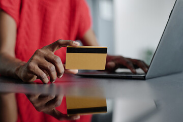 Medium close up of golden credit card in unrecognizable female hand