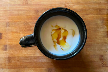 Mug of homemade Kefir yoghurt drink drizzled with maple syrup