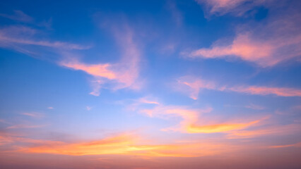 Dusk sky with yellow and orange clouds on horizon blue sunset sky background after sundown, Beautiful idyllic natural summer evening sky backdrop