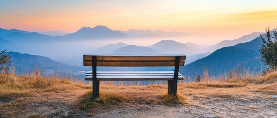 a wooden bench with mountains in the distance and morning sky