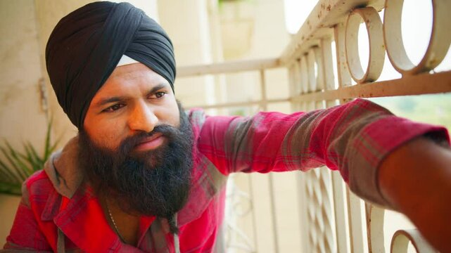Turban man worried and perplexed sits on terrace