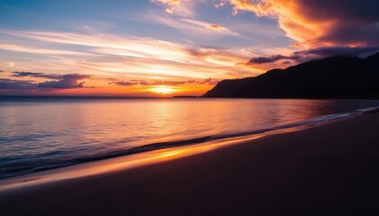 sunset on the beach with a mountain in the distance